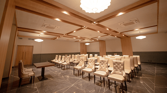 An image of a banquet hall featuring several chairs and a centre table at Pride Resort Ambaji